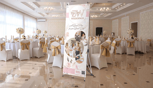 x banner stand displayed at indoor wedding venue