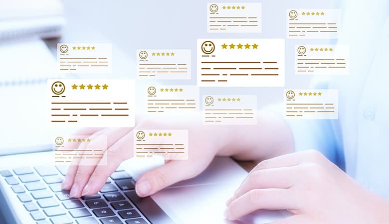 person researching on laptop with floating review bubbles hovering