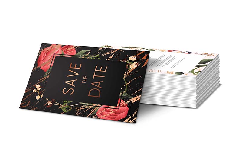 Save the date invitation propped up against a stack of invitations